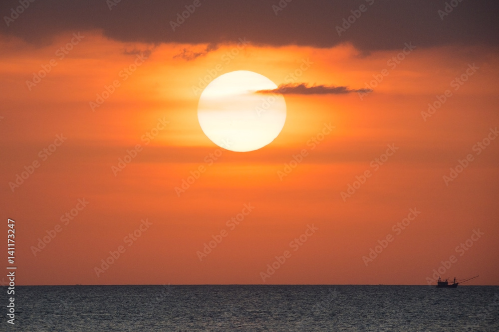 Big sun and a fisherman boat at sunset in Phuket - Thailand Big sun and a fisherman boat at sunset in Phuket - Thailand