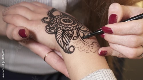 Woman making a mehendi with black henna photo