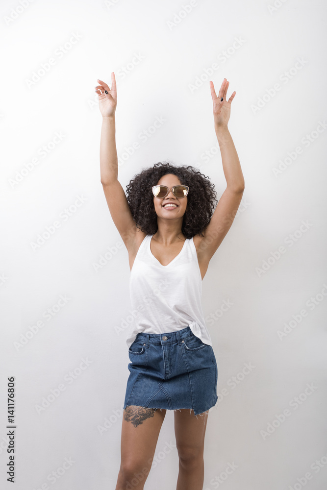 Stylish woman with tattoo on her leg raised arms up