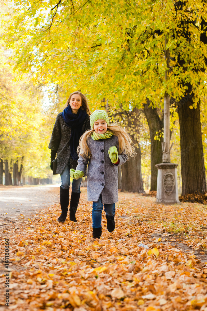 Fototapeta premium Mother walking with daughter outdoors in the autumn