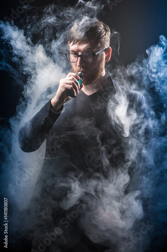 Smoking electronic cigarettes. Man in smoke