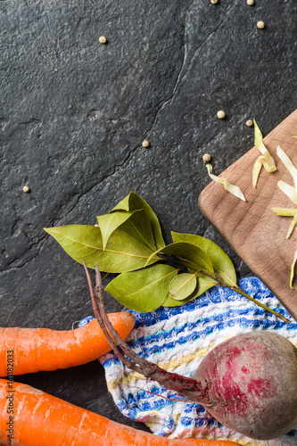 Beets, carrots and cabbage during cooking. Composition on a dark background. photo