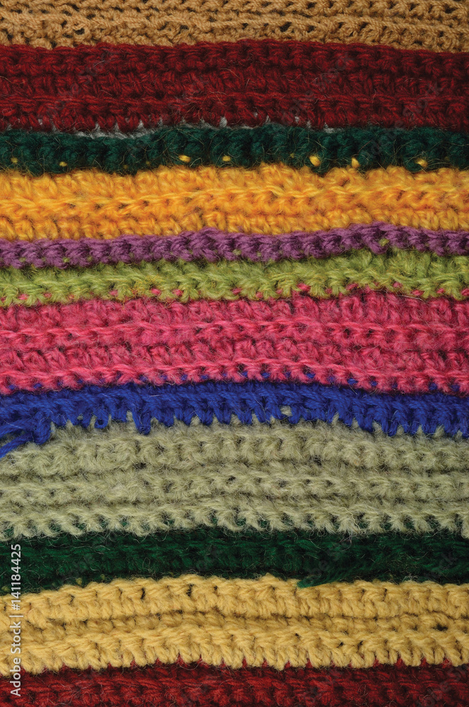 Knitted fine wool garment colorful stripes background natural texture, yellow, beige, claret, blue, green scarf macro closeup, large detailed textured knit pattern, vertical woolen