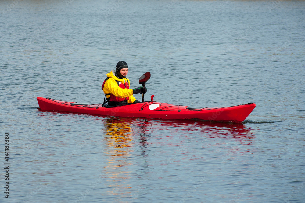 man kayaking on the red kayak on the river 