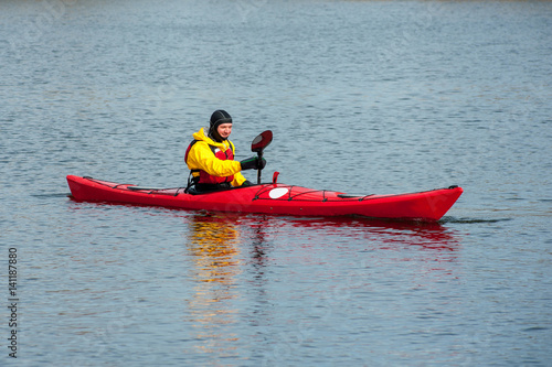 man kayaking on the red kayak on the river  © serguastock
