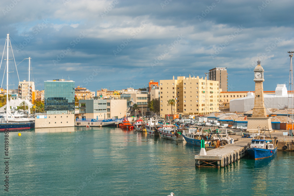 Fototapeta premium Łodzie zacumowane w porcie w Marina, Port Vell w Barcelonie, Hiszpania. Żaglówki, jachty, statki wycieczkowe i trawlery rybackie zacumowały w pobliżu miasta w ciepłej Barcelonie w listopadowe popołudnie.
