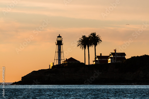 Silhouette of the new Point Loma lighthouse in San Diego, California with an orange sky.