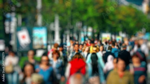 Crowd of People / Commuters Walking / Busy Street. Anonymous crowd on a busy street. People walk down a busy street with green trees on a hot summer day. Slow motion.