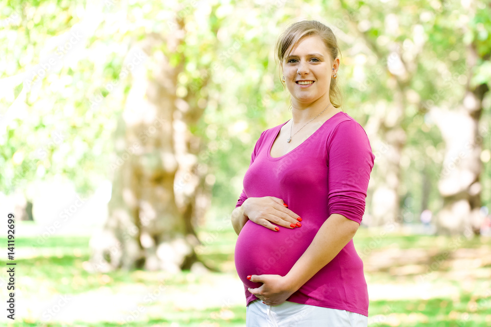 Happy and young pregnant woman in park in summer Happy and young pregnant woman in park in summer