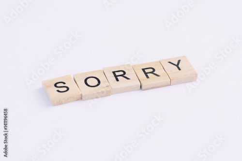 Text wooden blocks spelling the word sorry on white background