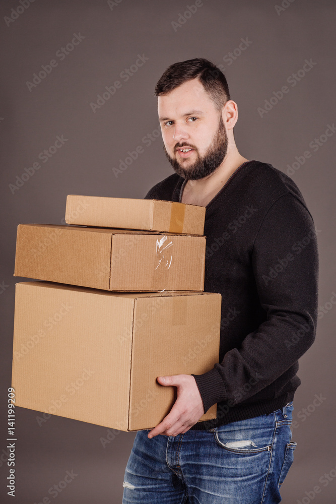 man holding pile of cardboard boxes in front man holding pile of cardboard boxes in front