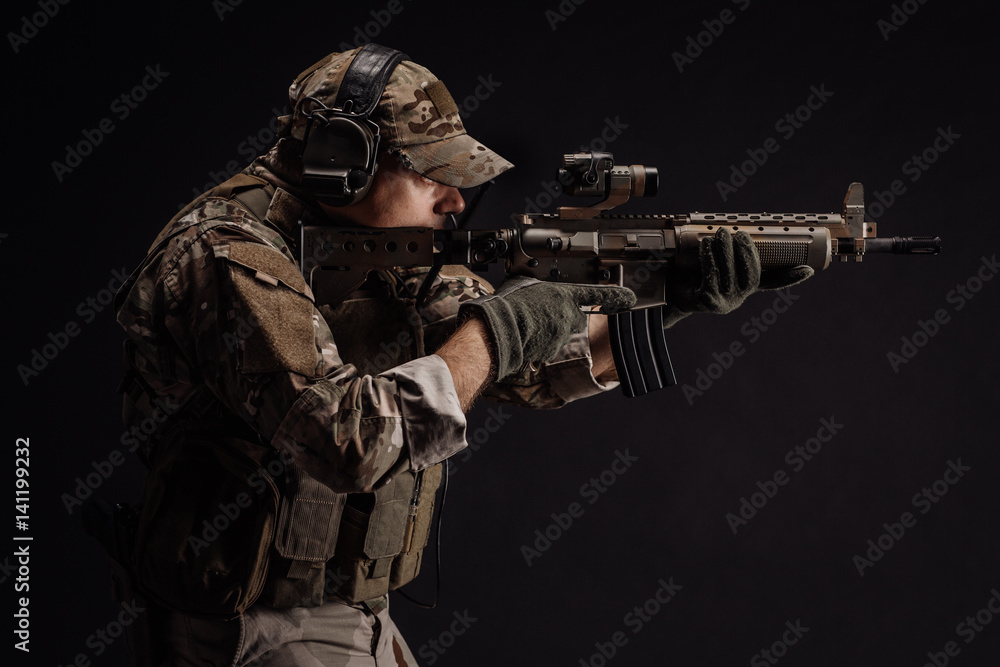 Portrait soldier or private military contractor holding sniper rifle. war, army, weapon, technology and people concept. Image on a black background. Portrait soldier or private military contractor holding sniper rifle. war, army, weapon, technology and people concept. Image on a black background.