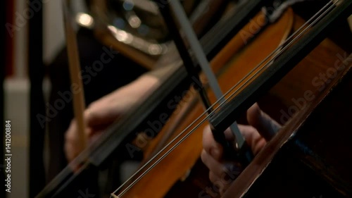 Musicians play violin instruments during the rehearsal of the symphony orchestra