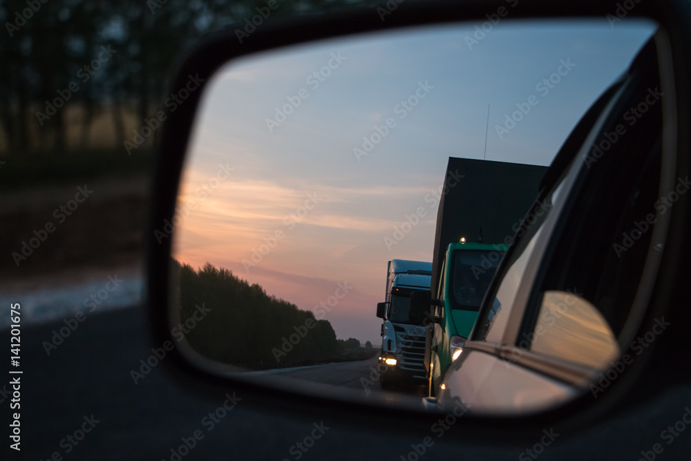 Road reflected in car mirror on a summer day
