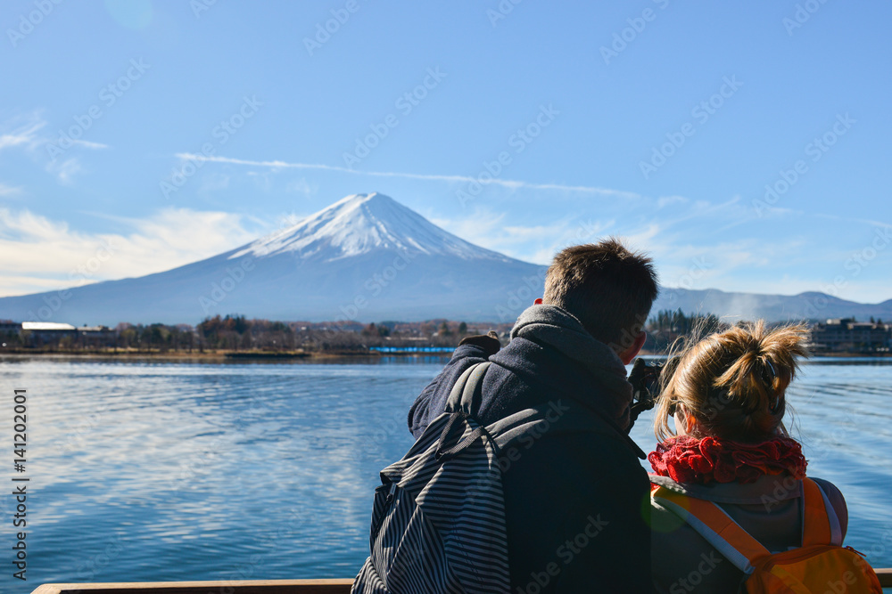 Fototapeta premium Tourists enjoy freely view Mt.Fuji from the pleasure boat at the Lake Kawaguchiko in winter , Japan