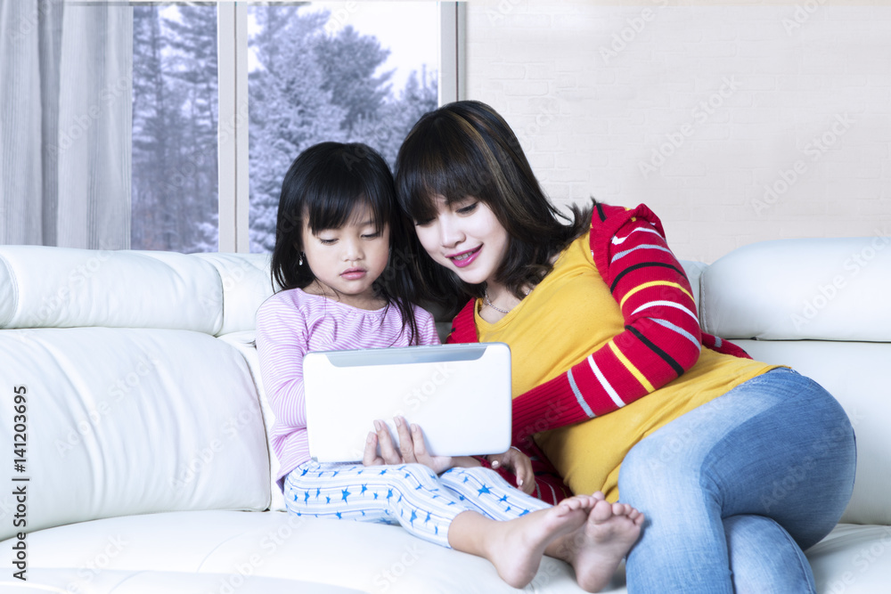 Cute child and mother playing tablet Cute child and mother playing tablet