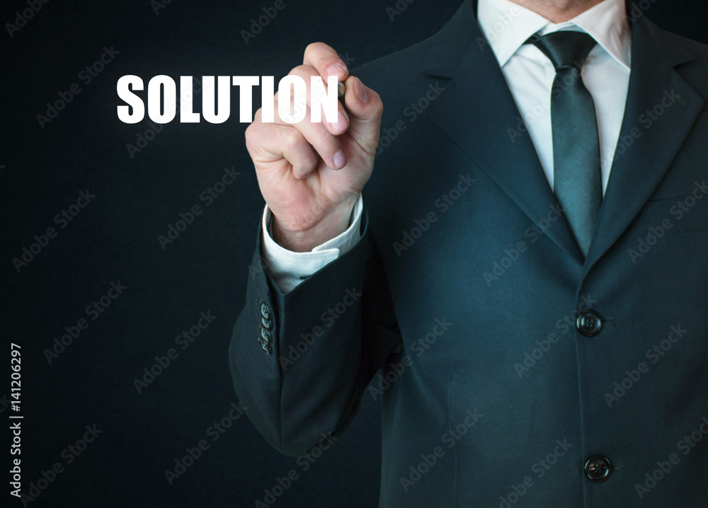 Businessman with a pen writing solution text. Businessman with a pen writing solution text.
