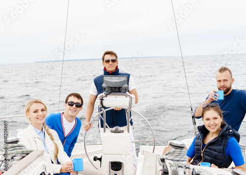 Happy friends traveling on a yacht and drinking a tea. Tourism, vacation, holiday, concept.