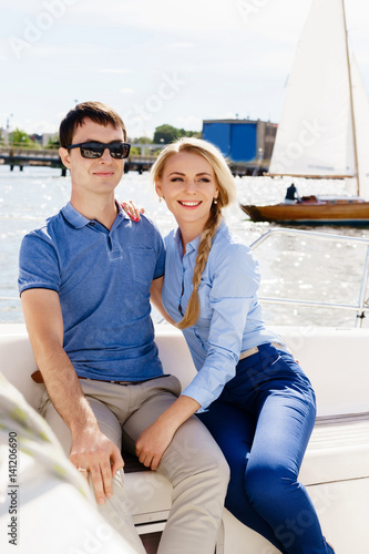 Happy and beautiful young couple having a rest on a yacht. Traveling, tourism, journey, concept. © Acronym