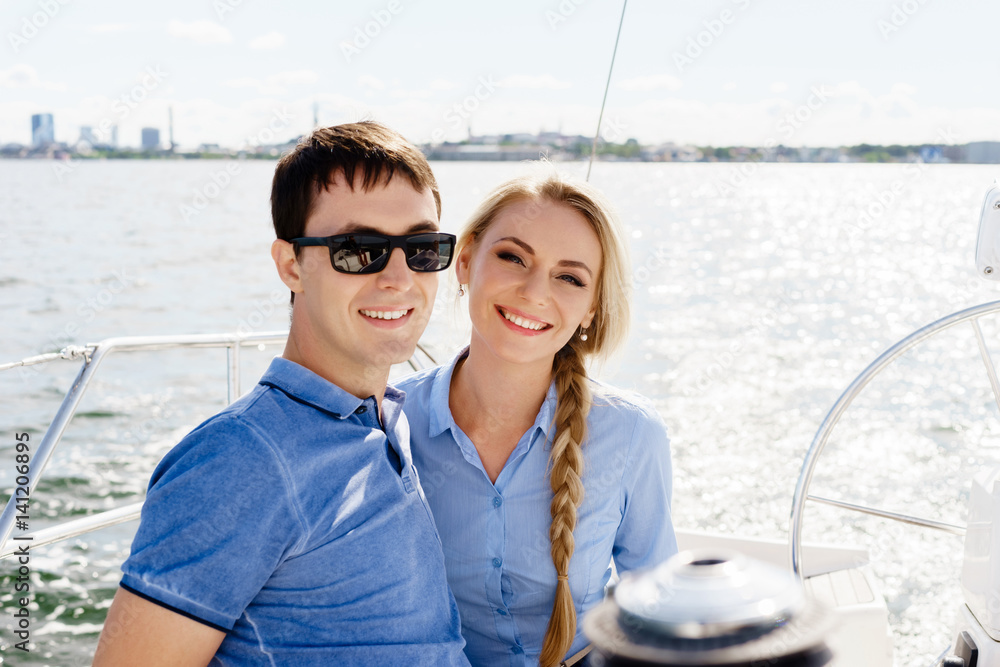 Happy and beautiful young couple having a rest on a yacht. Traveling, tourism, journey, concept.