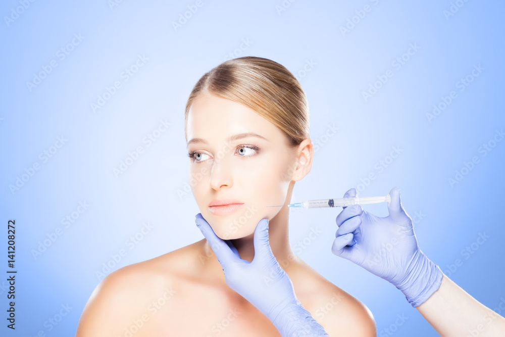 Doctor injecting in a beautiful face of a young woman. Plastic surgery concept. Doctor injecting in a beautiful face of a young woman. Plastic surgery concept.