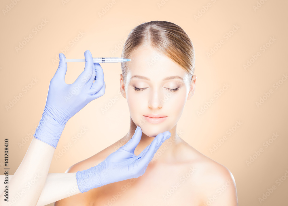 Doctor injecting in a beautiful face of a young woman. Plastic surgery concept. Doctor injecting in a beautiful face of a young woman. Plastic surgery concept.