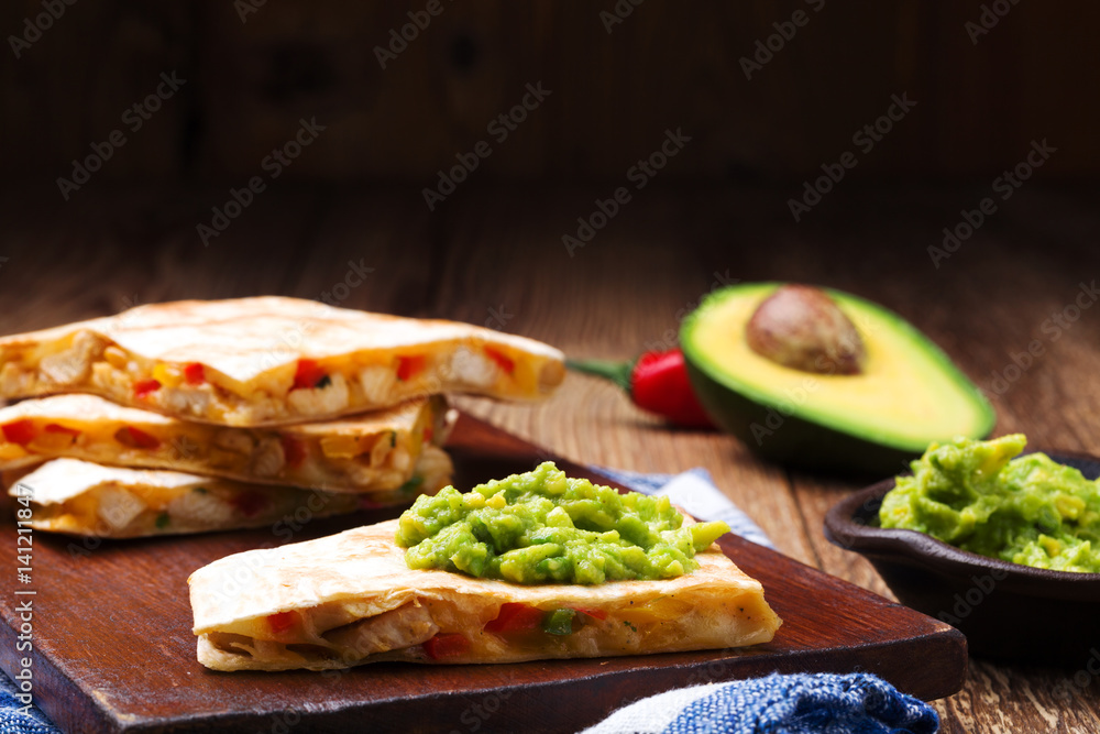 Quesadilla with chicken, served with guacamole or salsa sauce. Quesadilla with chicken, served with guacamole or salsa sauce.