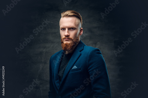 Redhead bearded hipster male dressed in a blue jacket.