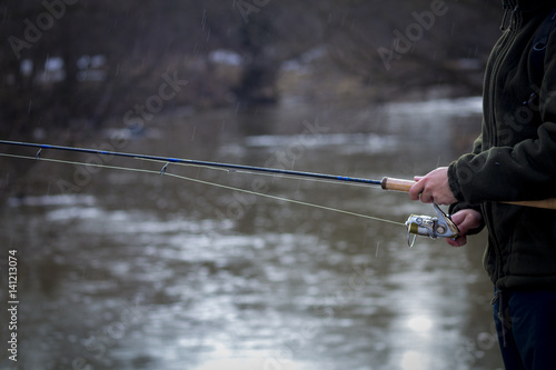Fishing in river.A fisherman with a fishing rod on the river bank. Man fisherman catches a fish