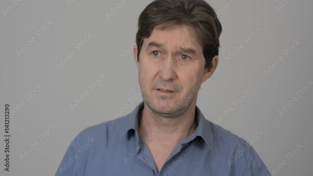 Adult man in a shirt singing, dancing, smiling over light background. Adult man in a shirt singing, dancing, smiling over light background.