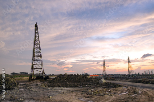 take photo of cranes for foundation in construction site work during sunset