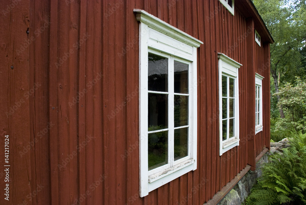 Fassade eines typisch skandinavischen roten Holzhauses Fassade eines typisch skandinavischen roten Holzhauses