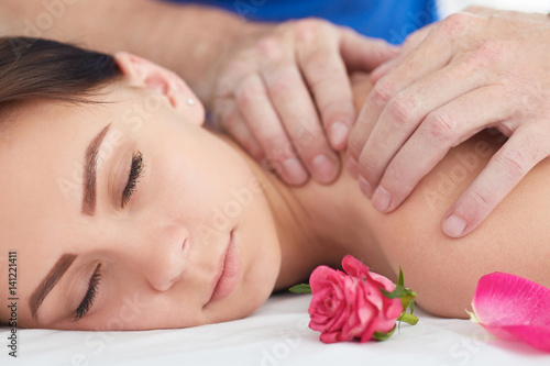 Woman enjoying a wellness neck massage in a spa. Health, beauty, resort and relaxation concept.