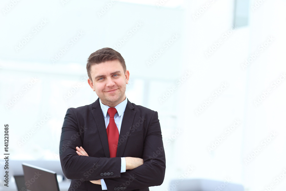 Successful businessman posing with crossed arms and smiling at camera Successful businessman posing with crossed arms and smiling at camera