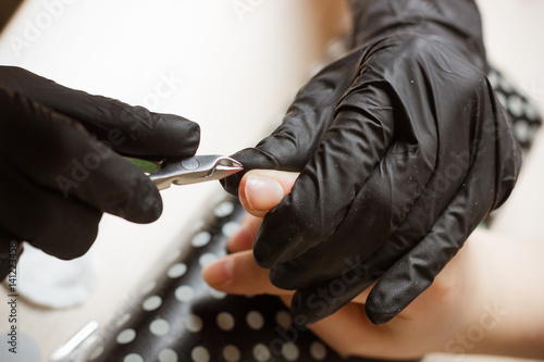 manicurist polishing index finger for manicure in nail beauty salon. Step of manicure process.