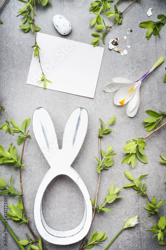 Easter greeting with blank white card , eggs, spring twigs , flowers and bunny decor, top view
