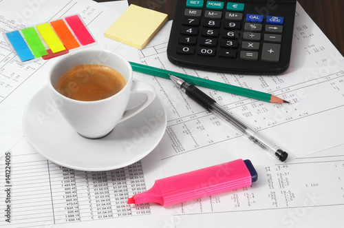 Calculator, papers, pen, pencil and cup of coffee on the table