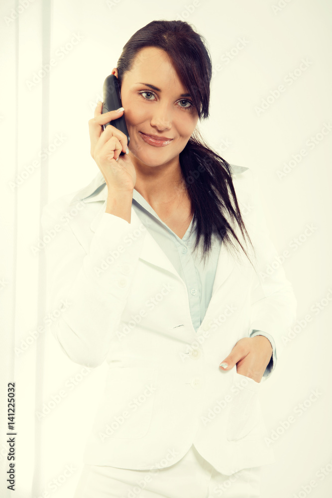 Attractive young woman having negotiations by phone in office Attractive young woman having negotiations by phone in office