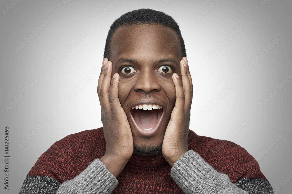 Close up portrait of excited African American male with shocked and