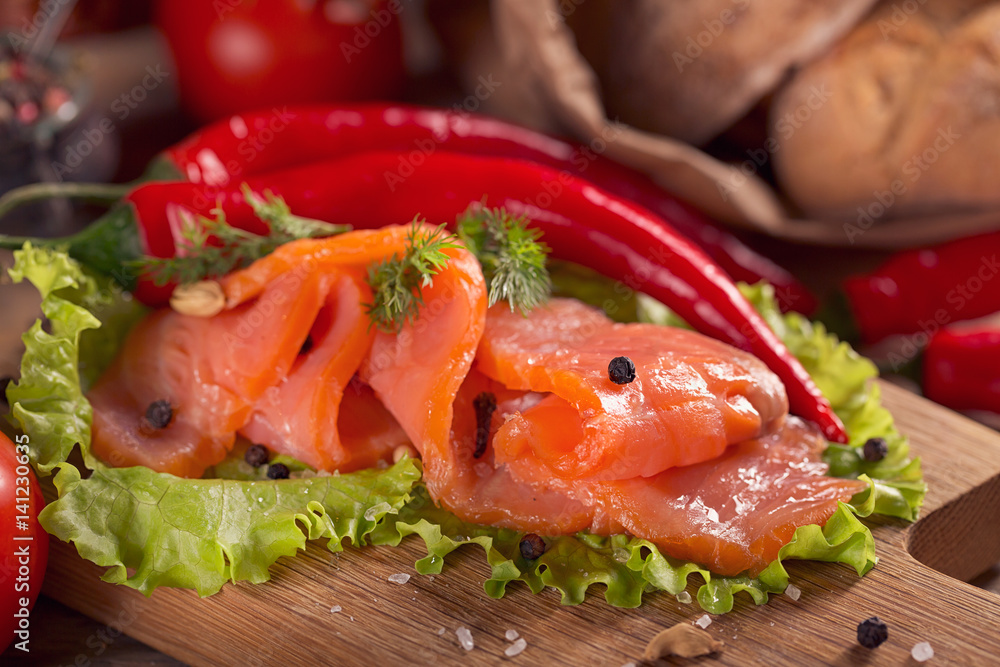 Slices of smoked salmon with dill, chile pepper, tomatoes and bread