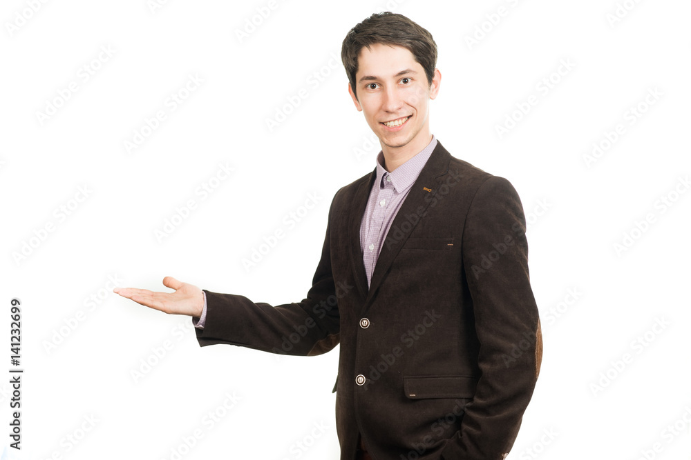 Handsome young businessman in suit smiling looking at camera holding a palm up Handsome young businessman in suit smiling looking at camera holding a palm up