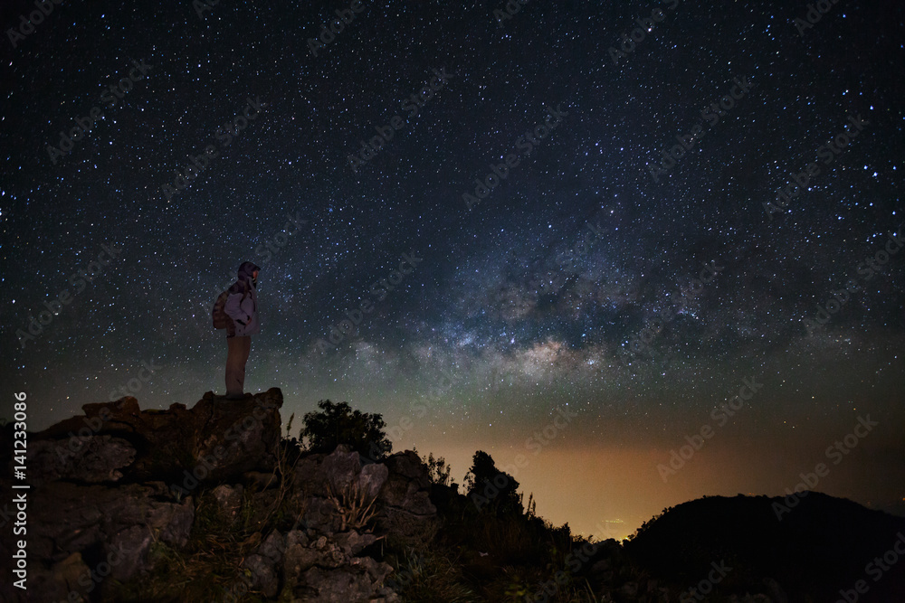Landscape with milky way, Night sky with stars and silhouette of a standing man on Doi Luang Chiang Dao mountain, Long exposure photograph, with grain