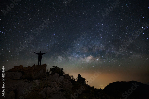 Landscape with milky way, Night sky with stars and silhouette of happy people standing on Doi Luang Chiang Dao mountain, Long exposure photograph, with grain