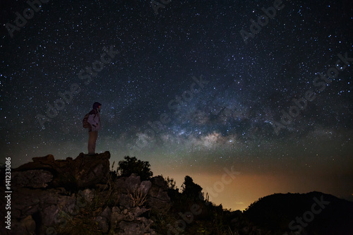 Landscape with milky way  Night sky with stars and silhouette of a standing man on Doi Luang Chiang Dao mountain  Long exposure photograph  with grain