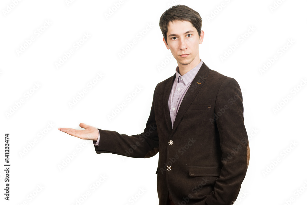 Handsome young businessman in suit smiling looking at camera holding a palm up Handsome young businessman in suit smiling looking at camera holding a palm up
