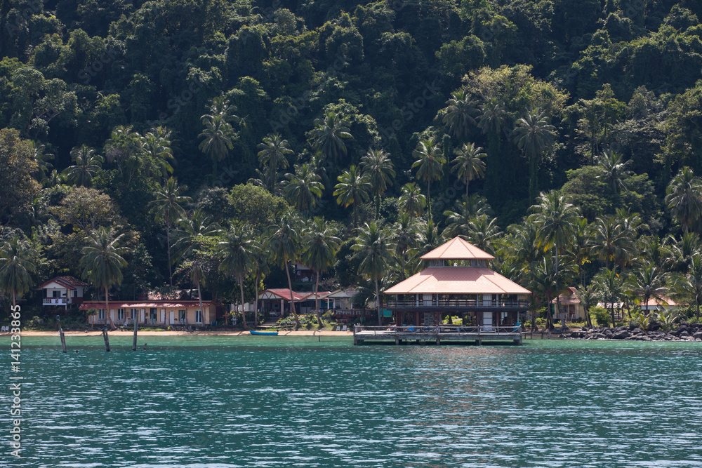 hotel on the shore of the island in the sea with palm trees and houses. Thailand, one of the small islands near the island of Koh Chang