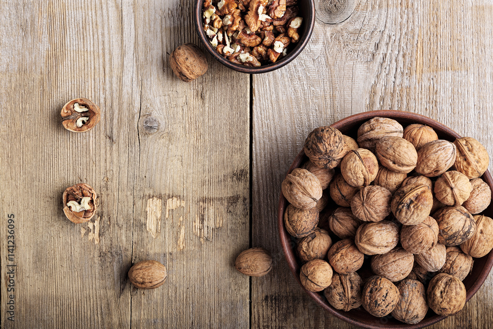 walnuts in a clay plate on a wooden background. top view walnuts in a clay plate on a wooden background. top view