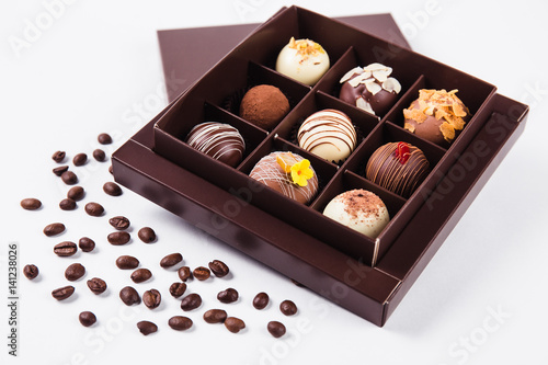 handmade chocolates in a square box and coffee beans near