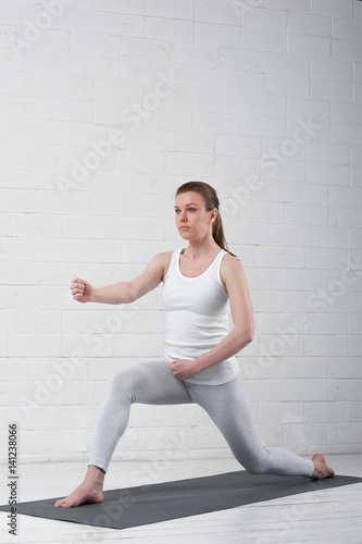 Young attractive woman doing yoga indoors.