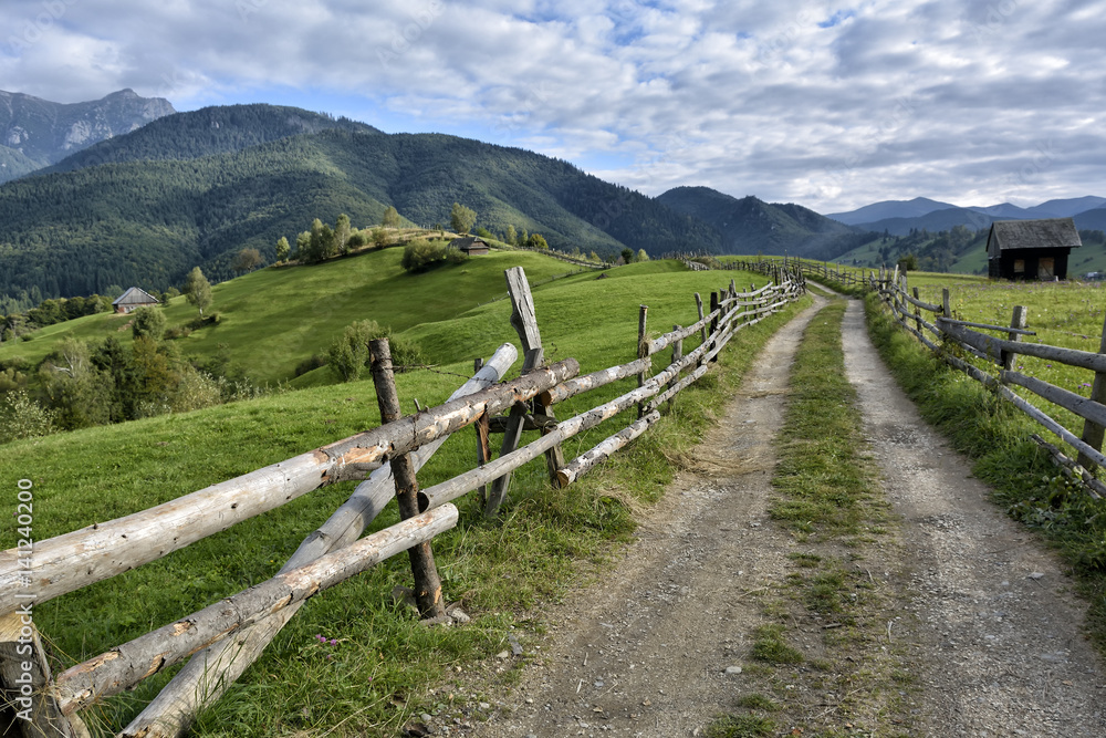 September rural scene in Carpathian mountains. Authentic village and fence